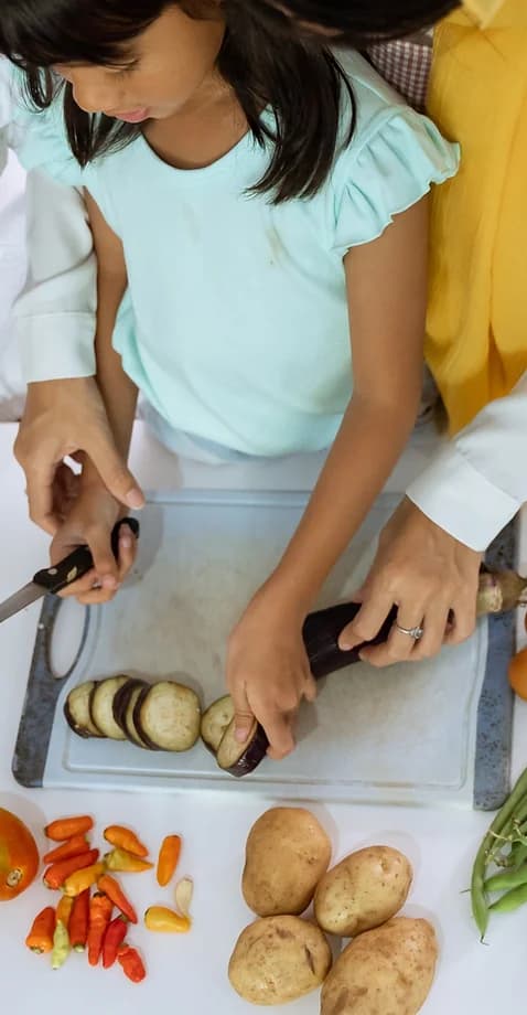 woman helping girl cook